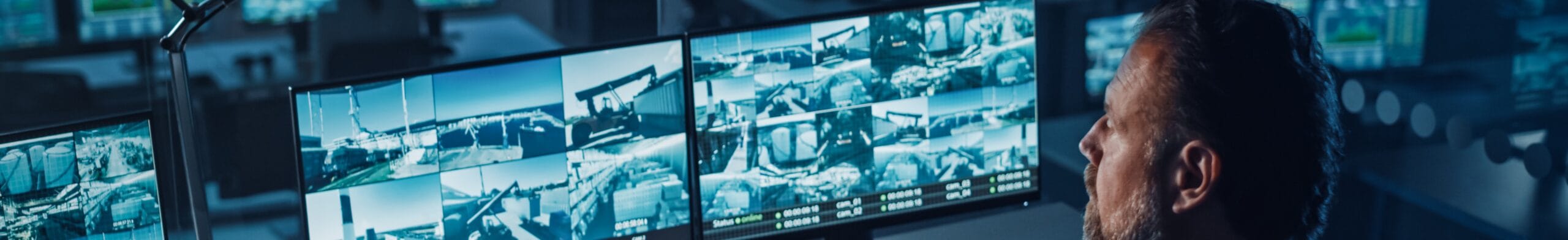 Security monitoring specialist observing multiple camera feeds in the central command center.